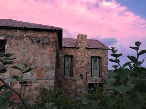 an old stone building with a pink sky at Fish Eagles View - on game farm close to pilansberg in Tiokweng