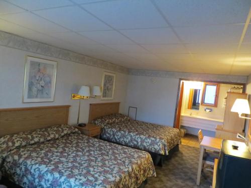 a hotel room with two beds and a window at Midtown Western Inn - Kearney in Kearney