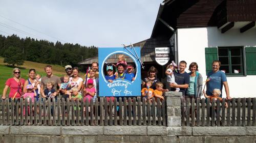 a group of people posing for a picture behind a fence at Viehberghütte in Sandl