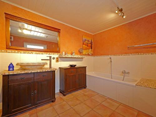 een badkamer met een bad, een wastafel, een bad en een spiegel bij Ferienwohnung _ Ferienhaus Krebs in Kiel