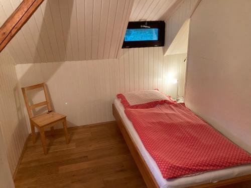 um pequeno quarto com uma cama e uma cadeira em Ferienhaus Juster im Wald em Gutenbrunn