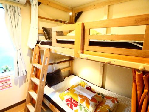 a room with two bunk beds and a ladder at ホステル富士山 結 in Fujiyoshida