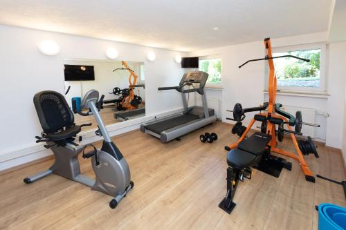 a gym with three exercise bikes in a room at Parkhotel Pyrmont in Bad Pyrmont