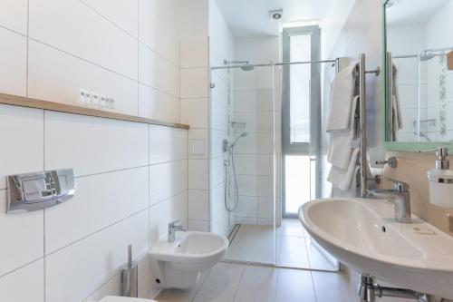 a white bathroom with a sink and a toilet at Villa St Maria in Jūrmala