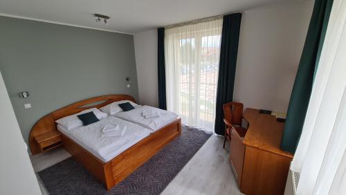 a bedroom with a bed and a large window at Port Club pension & restaurant in N&aacute;mestovo