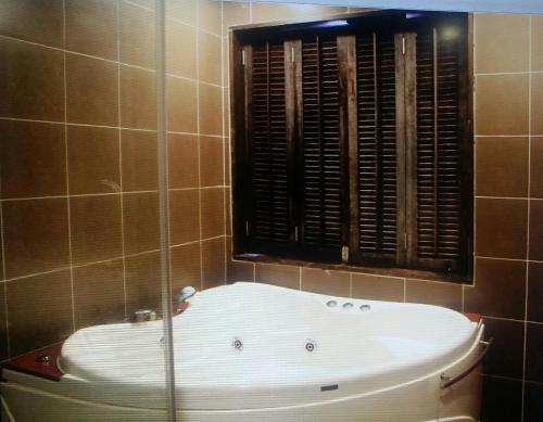a bath tub in a bathroom with a window at Marose Gold Coast Morib in Morib