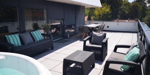 an outdoor patio with chairs and tables and a table at LAKE MOMENTS - Emerald Penthouse in Balatonszemes