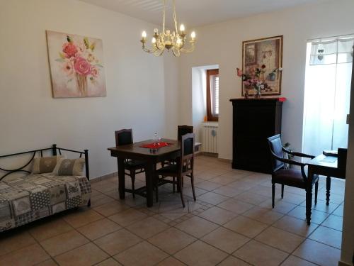 uma sala de estar com uma mesa e cadeiras e uma cama em La piazzetta em Pignola