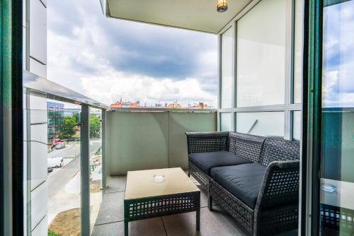 a balcony with a couch and a table at Apartments Poznan Towarowa by Renters in Poznań