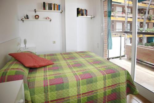 a bedroom with a bed with a green at AT141 Els Pins, comunidad con piscina en primera línea in Torredembarra