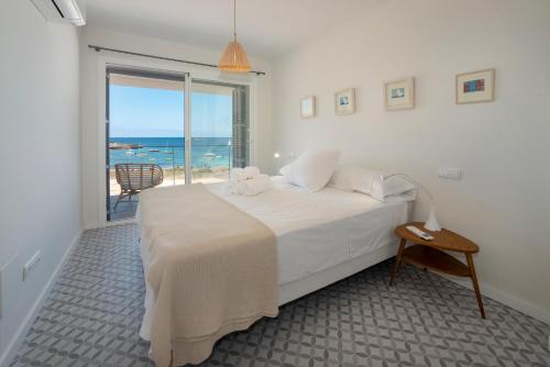 a bedroom with a bed with a view of the ocean at BLAU Apartamento en Cala Galiota con vistas al mar in Colonia Sant Jordi