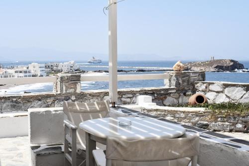 a table and chairs on a balcony with a view of the ocean at Iliada Suites in Naxos Chora