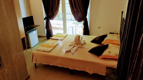 a bed with two dolls sitting on top of it at Dracena Guesthouse in Ravda