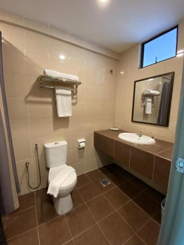 a bathroom with a toilet and a sink at KSB Village Resort in Kampong Hilir