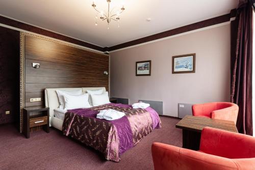 a hotel room with a bed and a chair at Bukovel Apart in Bukovel