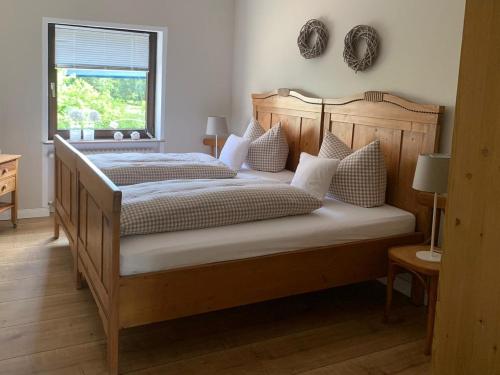 um quarto com uma grande cama de madeira com almofadas brancas em Haus 8 em Lauterecken