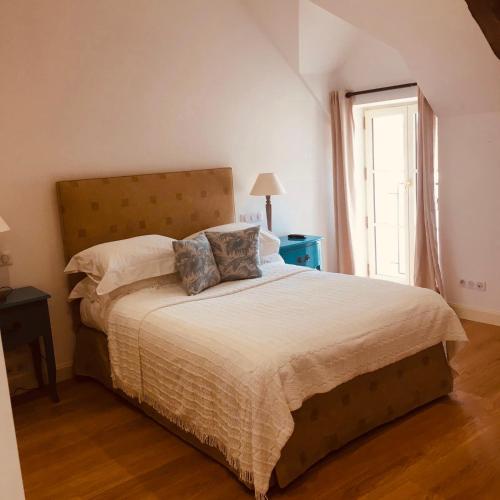 une chambre avec un grand lit et une fenêtre dans l'établissement Apartment in a working winery with private rooftop terrace, à Marigny-Brizay