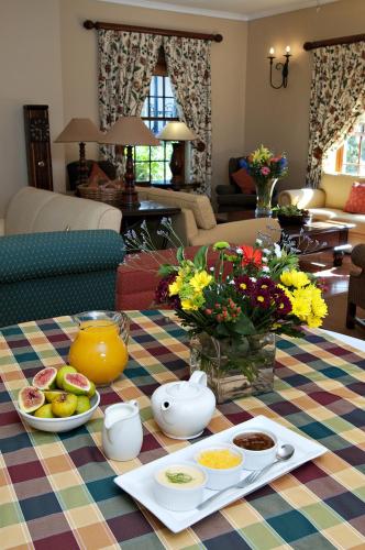 a table with plates of food on a colorful table cloth at Ongegund Lodge in Somerset West