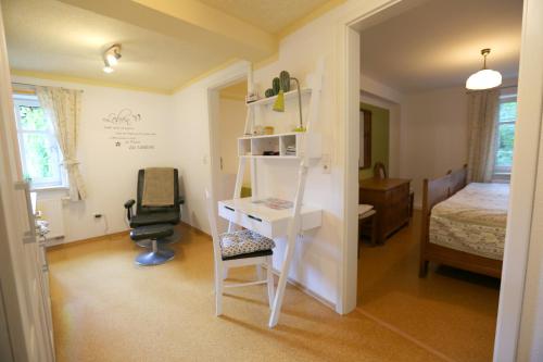 a room with a desk and a bedroom with a bed at Ferienwohnung „Alte Mühle“ in Bad Rodach