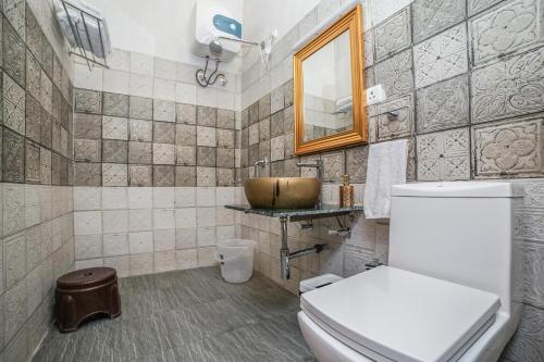 a bathroom with a toilet and a sink at The Brigadiers Cottage, Mussoorie in Mussoorie