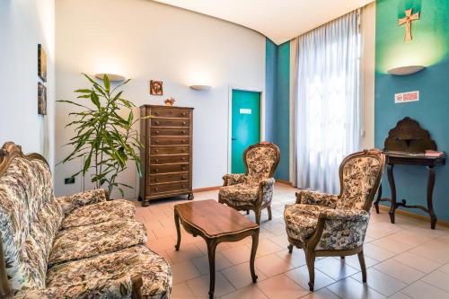 a living room with a couch and chairs and a piano at Il Seminario in Alba