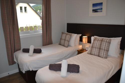 two twin beds in a room with a window at Glencoe view lodge in Glencoe