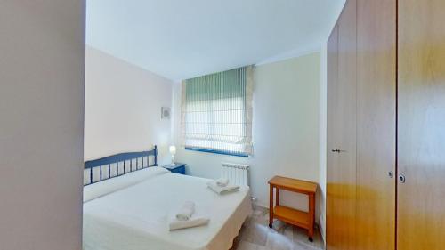 カラフェルにあるCalafell Sant Antoniの小さなベッドルーム(ベッド1台、椅子付)