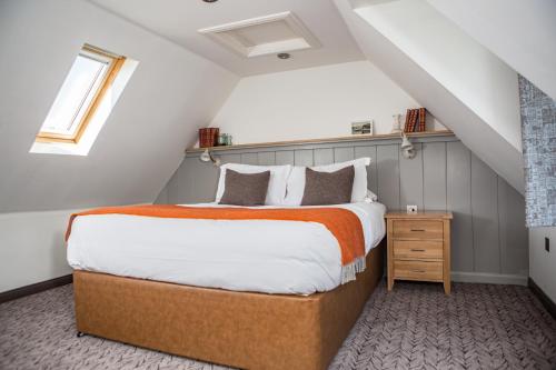 a bedroom with a large bed in a attic at Bosville Hotel in Portree