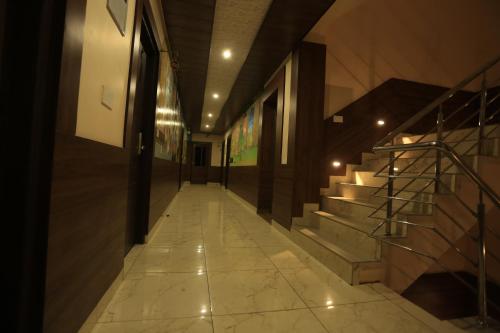 a hallway with stairs in a building with lights at Hotel Buddha House Himalayan Brothers in Dharamshala