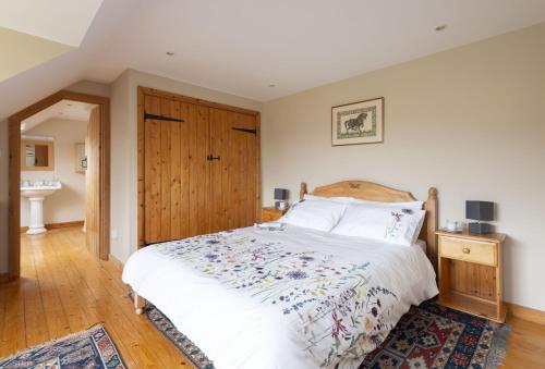 a bedroom with a bed and a wooden door at Greygles in Dorchester