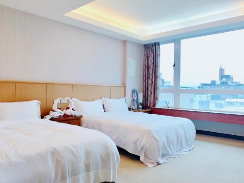 宜蘭市的住宿－慕夏精品旅館，配有大窗户的酒店客房内的两张床