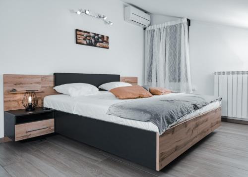 a bedroom with a large bed with a wooden headboard at Istriana boutique apartment in Nova Gorica