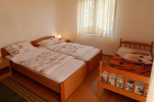 um pequeno quarto com 2 camas e uma janela em Apartman Svjetličić em Brzac
