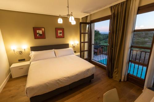 um quarto com uma cama grande e uma varanda em Torre de Briñas Private Resort em Briñas