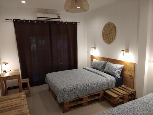 a bedroom with two twin beds and a window at La Locanda in Bangkok