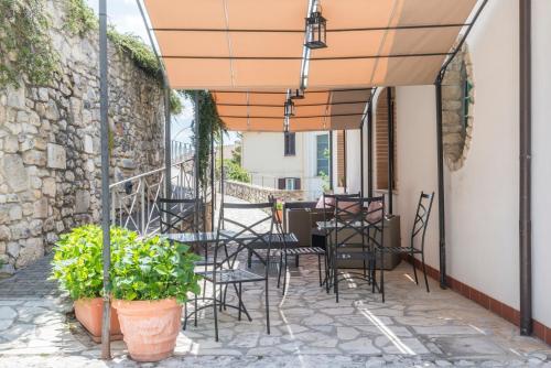 a patio with chairs and tables and a stone wall at Il Lavatoio Dimora Storica in Castel di Sangro