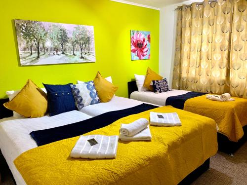 2 letti in una camera con pareti gialle di Spacious London Excel 2 bedrooms, Separate Reception, Kitchen, Full Apartment a Londra