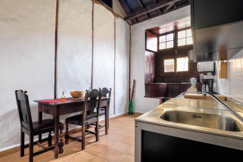 cocina con mesa con sillas y fregadero en Casa Tradicional Canaria - I en Garachico