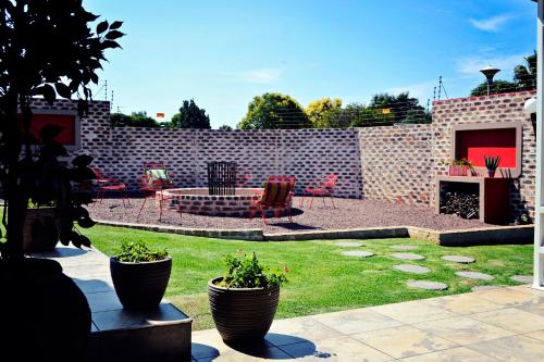 a backyard with a brick wall and a patio with plants at Bokmakierie Gastehuis Emalahleni Pty Ltd in Witbank