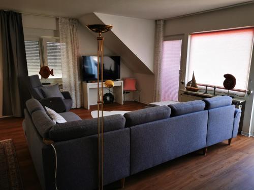 a living room with a blue couch and a tv at Ferienwohnungen und Ferienhaus im Nixenweg in Hohwacht