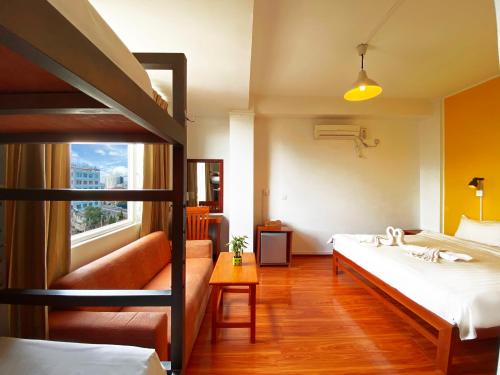 a bedroom with two bunk beds and a couch at Ostello Bello Mandalay in Mandalay