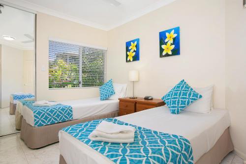 a bedroom with two beds and a window at The Beach House 3BR Waterfront Apartment, Own WIFI in Trinity Beach