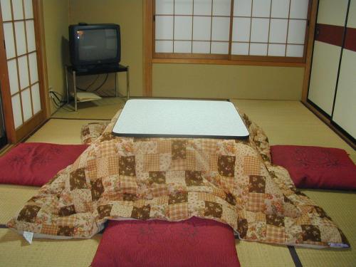 un letto in una stanza con una trapunta sul pavimento di Cottage Karuizawa a Karuizawa