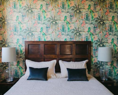 a bedroom with a bed with a floral wallpaper at The Old Confectionery in Oamaru