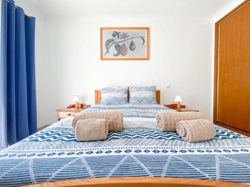 Un dormitorio con una cama azul y blanca con cortinas azules en Casa do Farol - Apartamento com piscina junto à Praia do Camilo, en Lagos