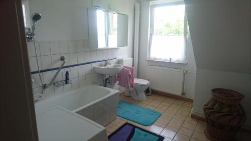 a bathroom with a tub and a sink and a toilet at Kummerower See in Dargun