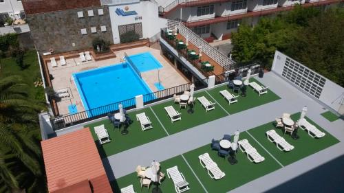 una vista aérea de una piscina con tumbonas y mesa de billar en Hotel Sarga en Cabañas