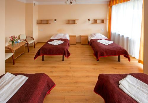 a hospital room with three beds and a table at Ośrodek Uzdrowiskowy Biawena in Wysowa-Zdrój