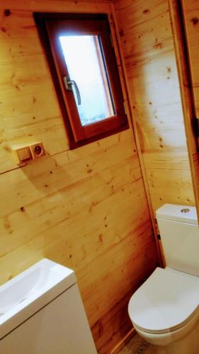 La salle de bains en bois est pourvue de toilettes et d'une fenêtre. dans l'établissement Nîmes en Garrigues, à Nîmes