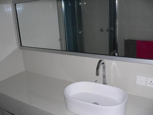 a white sink in a bathroom with a mirror at Gästehaus Isabella in Beruwala